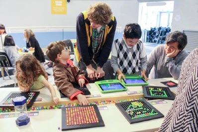 Ein Lehrer erklärt Schüler*innen das Spiel "Bloxels"