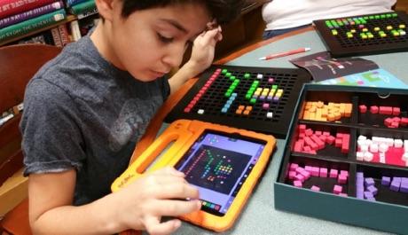 Ein Schüler überträgt seine Bloxels-Kreation auf die App.
