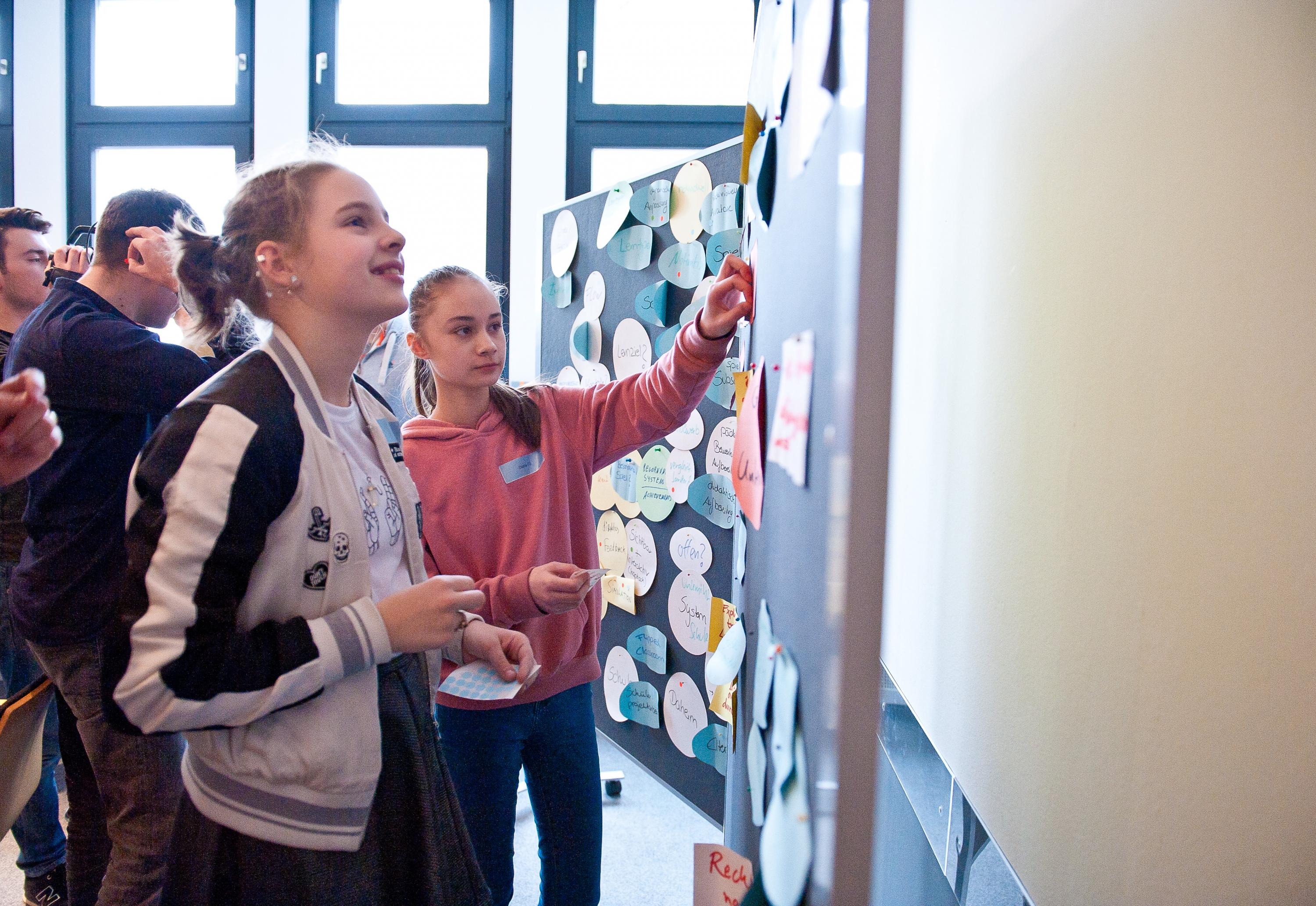 Schüler*innen vor Pinnwand