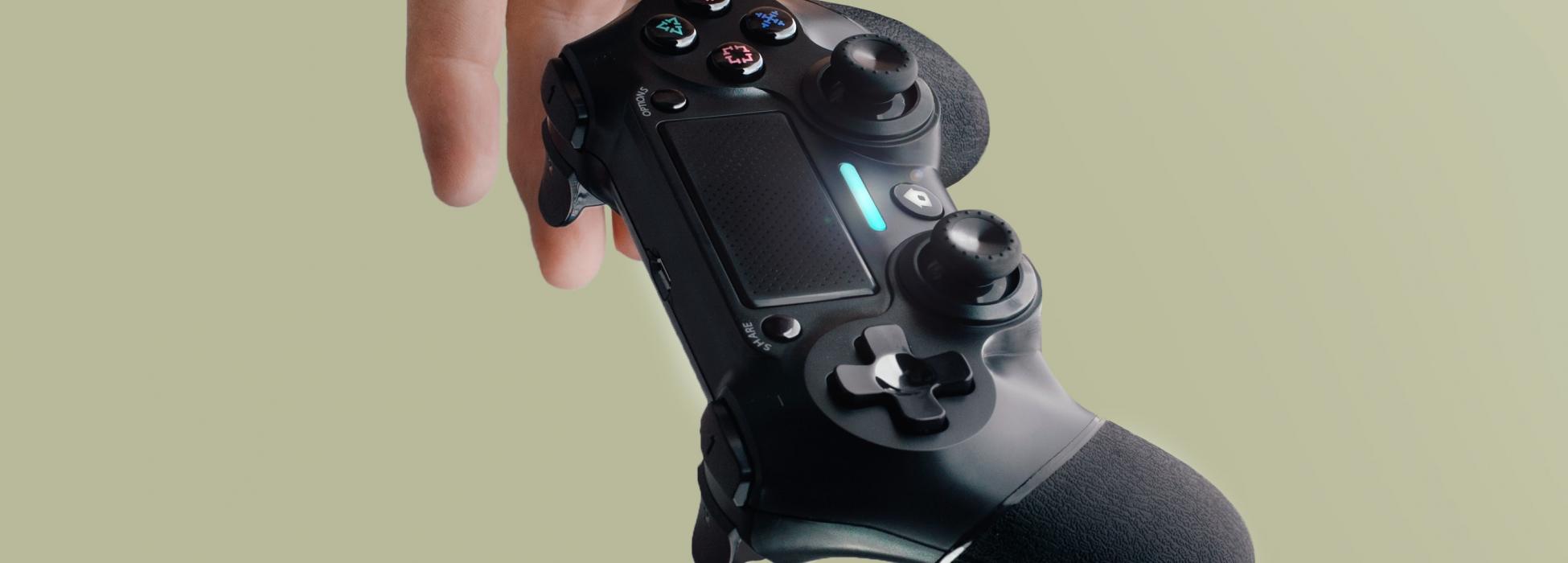 Foto: Lucas Ortiz, Unsplash Eine Hand, die einen Controller fallen lässt vor blassgrünem Hintergrund