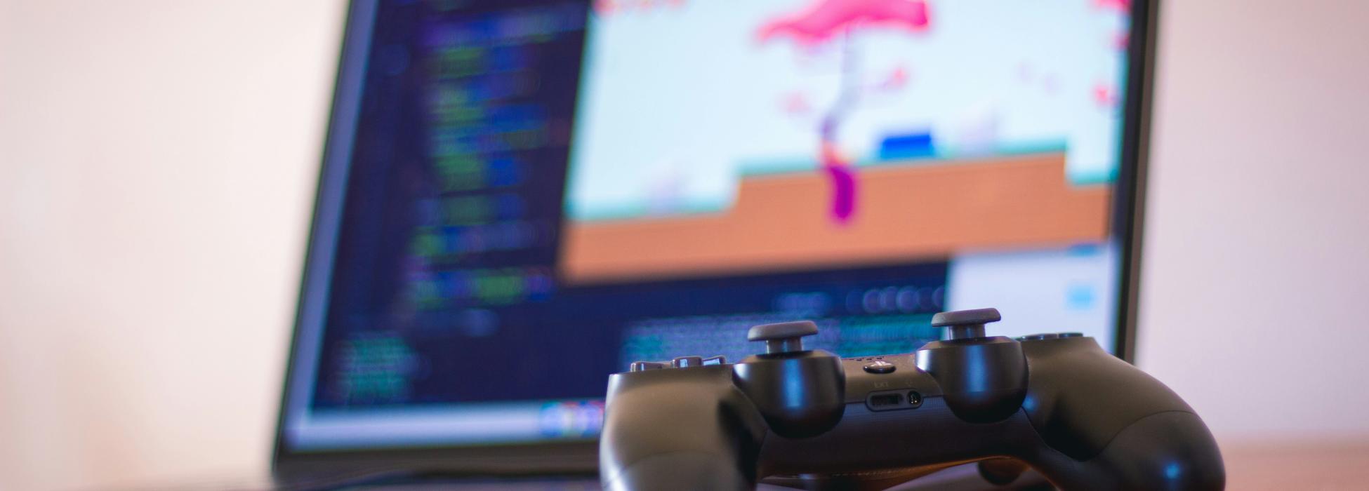 Symbolbild Game Development Schwarzer Laptop mit Controller